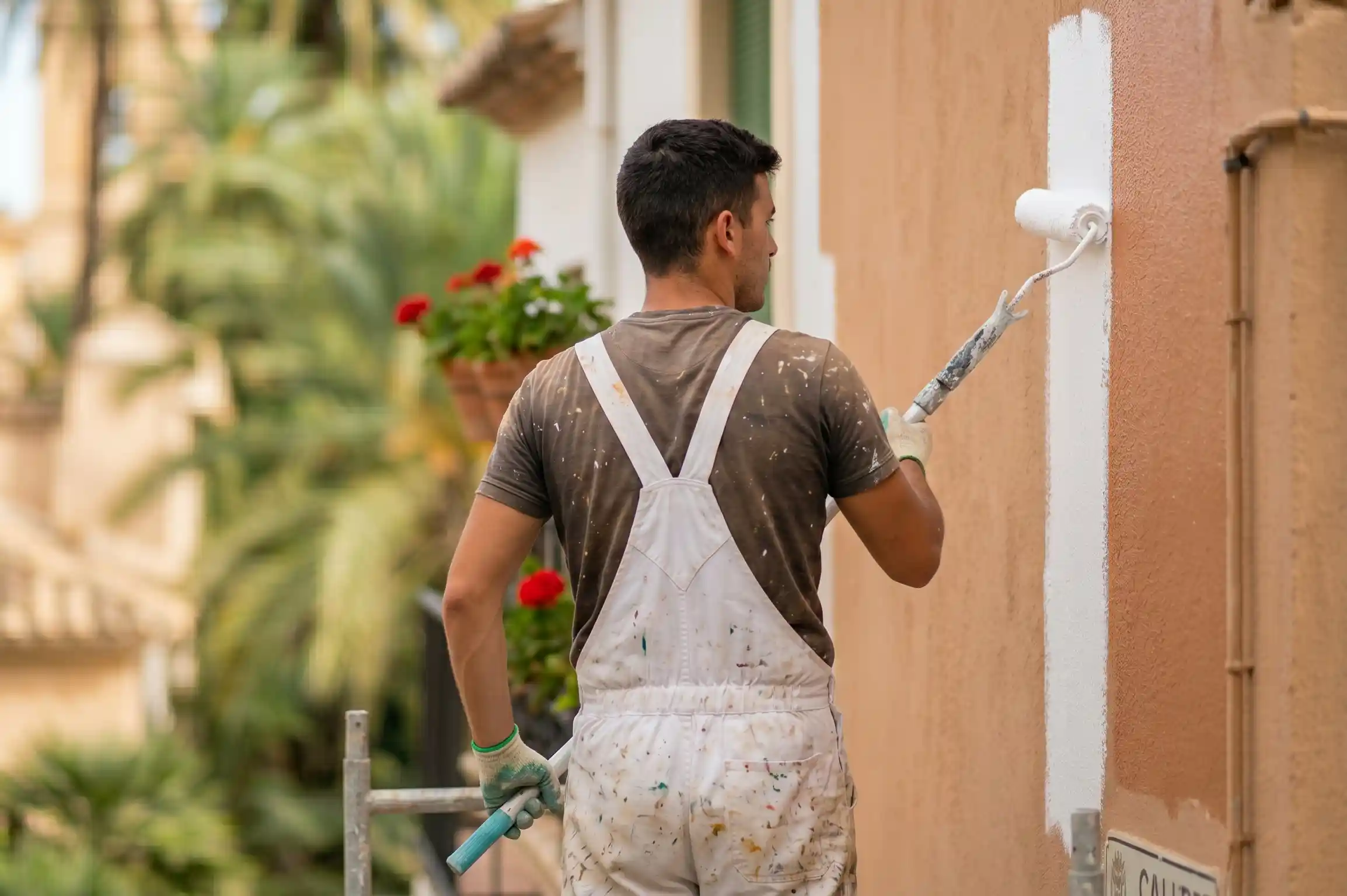 Pintor renovando la fachada de una casa en Elche